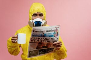 Man in toxic waste costume reading the newspaper and drinking coffee